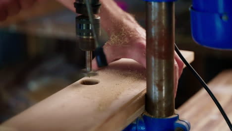 person using a power drill to make a hole in wood