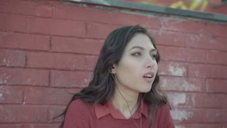 Girl-speaking-She-tells-a-story-with-brick-wall-in-the-background