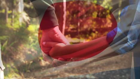 animation of flag of japan over caucasian father with son holding hands