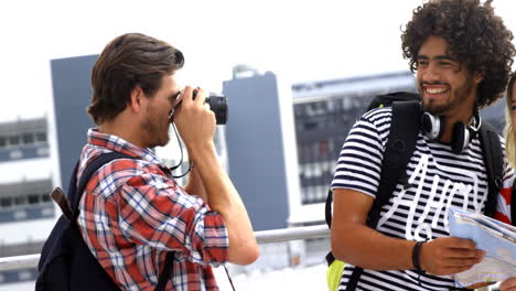 un chico hipster tomando fotos de sus amigos