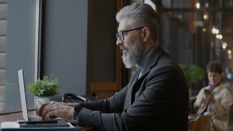 businessman working on laptop in a cafe