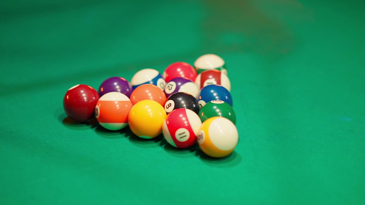 Hands Racking Colorful Billiard Balls on a Green Pool Table