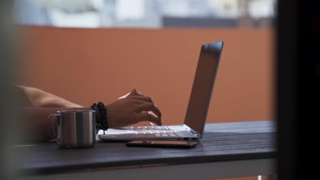 Closeup-footage-of-a-male-typing-on-the-laptop-at-the-table