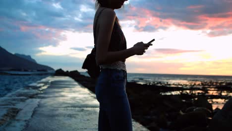mujer tomando una selfie en el paseo marítimo en la playa 4k