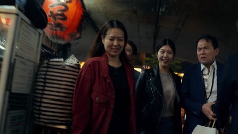 group of friends walking through a night market in a city tunnel