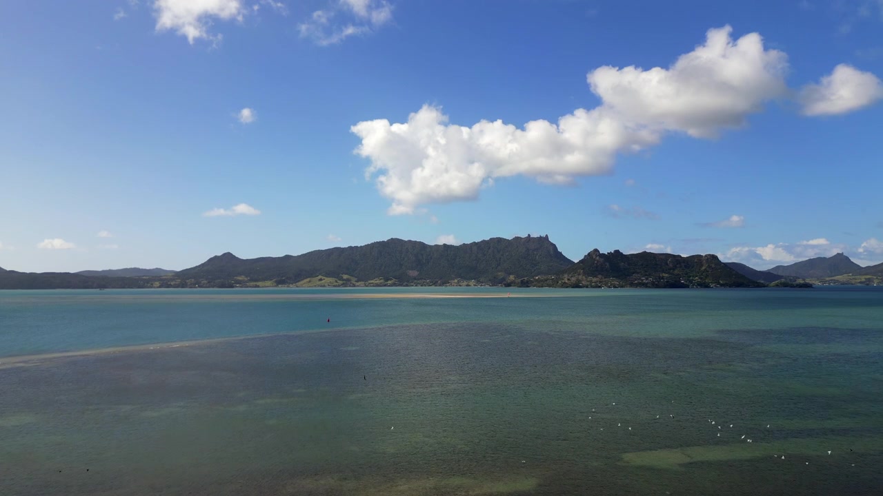 ニュージーランド北島ワントゥリーポイント、地平線にマウントマナイア、ドローンによる海上からの進入、4K 30FPS