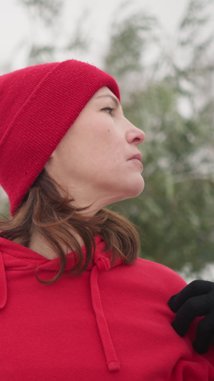 close-up of coach with hands on shoulders turning head slowly to right, snow-covered landscape with frosted trees in background, serene winter outdoor setting with peaceful atmosphere