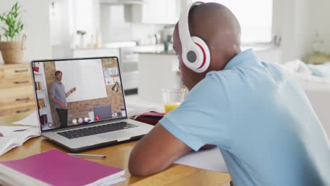 Animation-of-african-american-boy-in-headphones-having-online-lessons-on-laptop