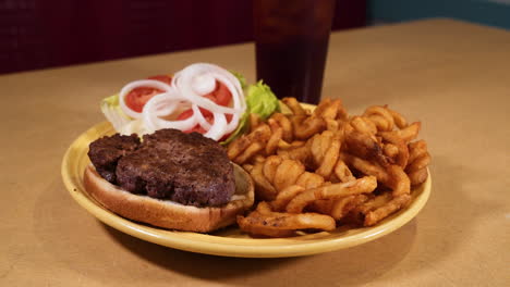 Saftiger-Hamburger-Und-Knusprige-Lockige-Pommes,-Amerikanischer-Burger-Auf-Gelbem-Teller,-Schieberegler-In-Zeitlupe-Hd