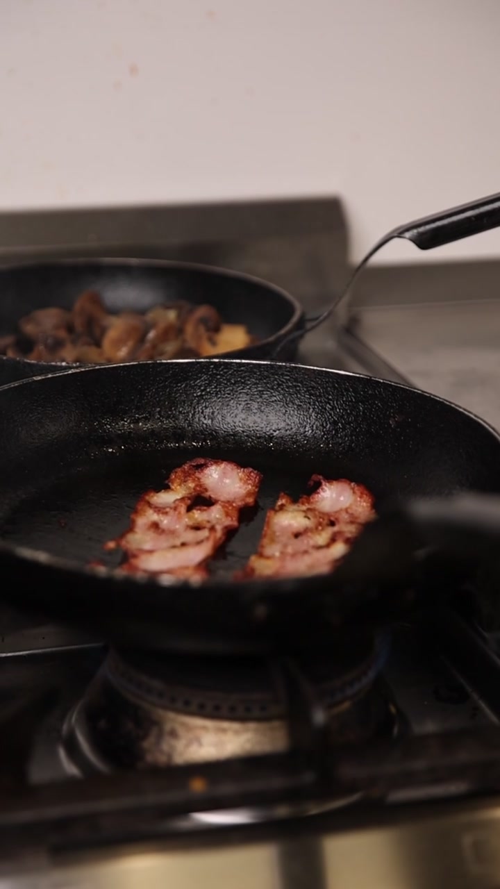 Primo piano della pancetta che sfrigola in padella