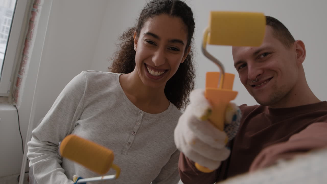 Happy Couple Painting Their New Home Together