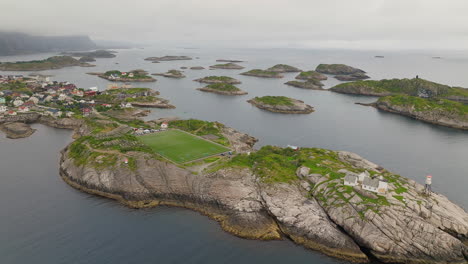 scenic setting of henningsvaer football pitch in lofoten archipelago, aerial arc