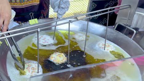 vendedor fritando cacahuetes en el puesto flotante del mercado