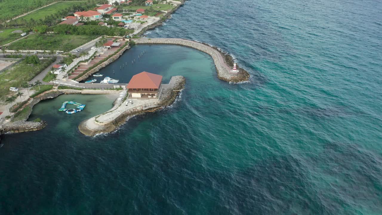Carrellata all'indietro mentre l'acqua calda si scontra con il frangiflutti in una giornata di sole