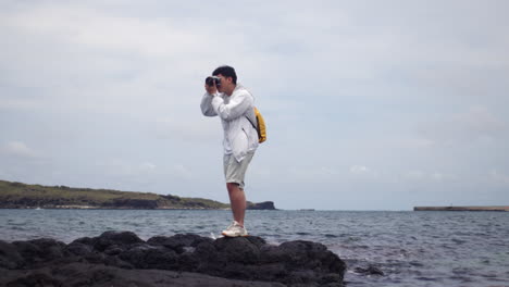 Portrait-Of-A-Guy-With-A-Camera-On-The-Rocky-Shoreline