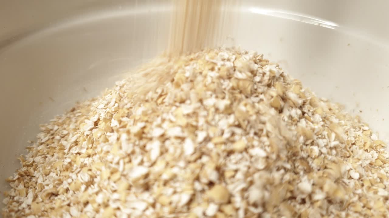 귀리 밀기울이 하얀 그릇에 떨어진다