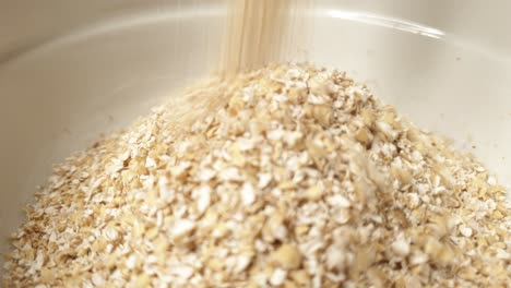 oat bran falls into white bowl