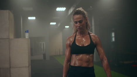 a tired woman at a gym training session is preparing to perform new exercises. concentration and attitude to training