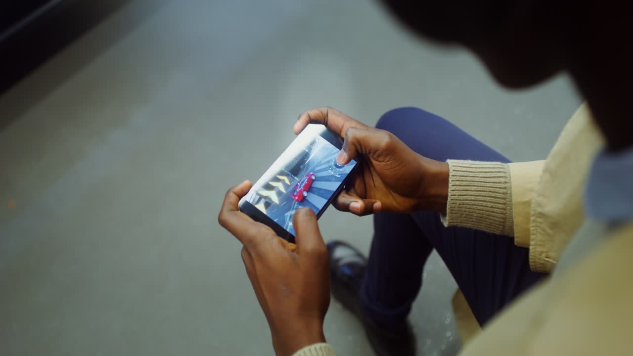 Persona che gioca a un videogioco di corse automobilistiche su uno smartphone