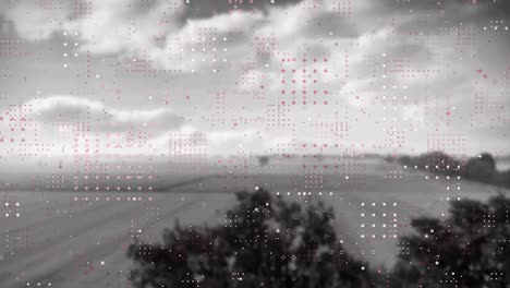 Animation-of-networks-of-dots-moving-over-black-and-white-countryside-and-cloudy-sky-background