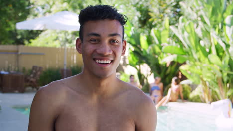 smiling bare chested african american man outdoors with friends enjoying summer pool party