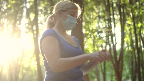 a woman in a medical mask treats her hands with antiseptic 03