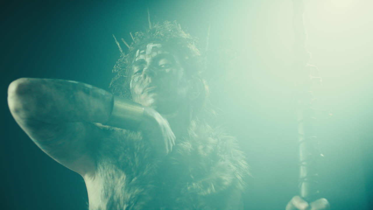 A creepy witch stands in the moody pose during the night storm