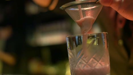 close up on fresh tropical cocktail mix being tipped into filter and cup filmed in slow motion