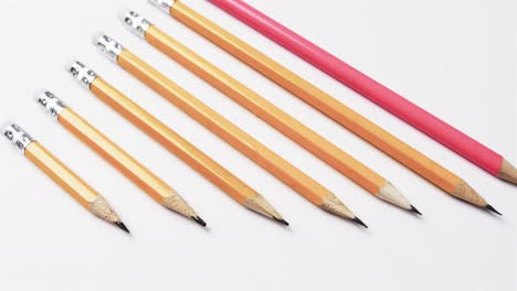 Close-up-of-pencils-arranged-on-white-background,-in-slow-motion