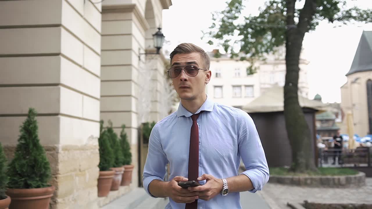 A handsome man in a business suit is walking around the city