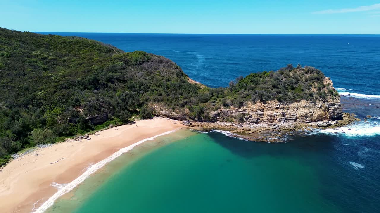 Ripresa aerea del paesaggio con drone che mostra boscaglia, falesia, promontorio costiero, litorale di Maitland Bay, sentiero escursionistico, spiaggia, oceano e mare. Scena ideale per viaggi e turismo nella Costa Centrale del Nuovo Galles del Sud, Australia. 4K