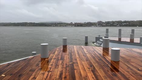 lapso de tiempo de un muelle, río y nubes con un tren que pasa al otro lado del río