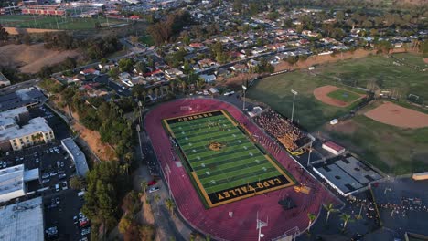 Excelente-Vista-Aérea-Retrocediendo-De-Un-Partido-De-Fútbol-En-La-Escuela-Secundaria-De-Capo-Valley