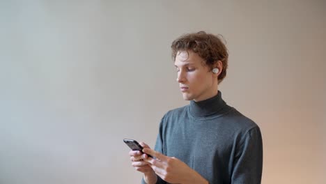 a young guy listens to music in portable headphones