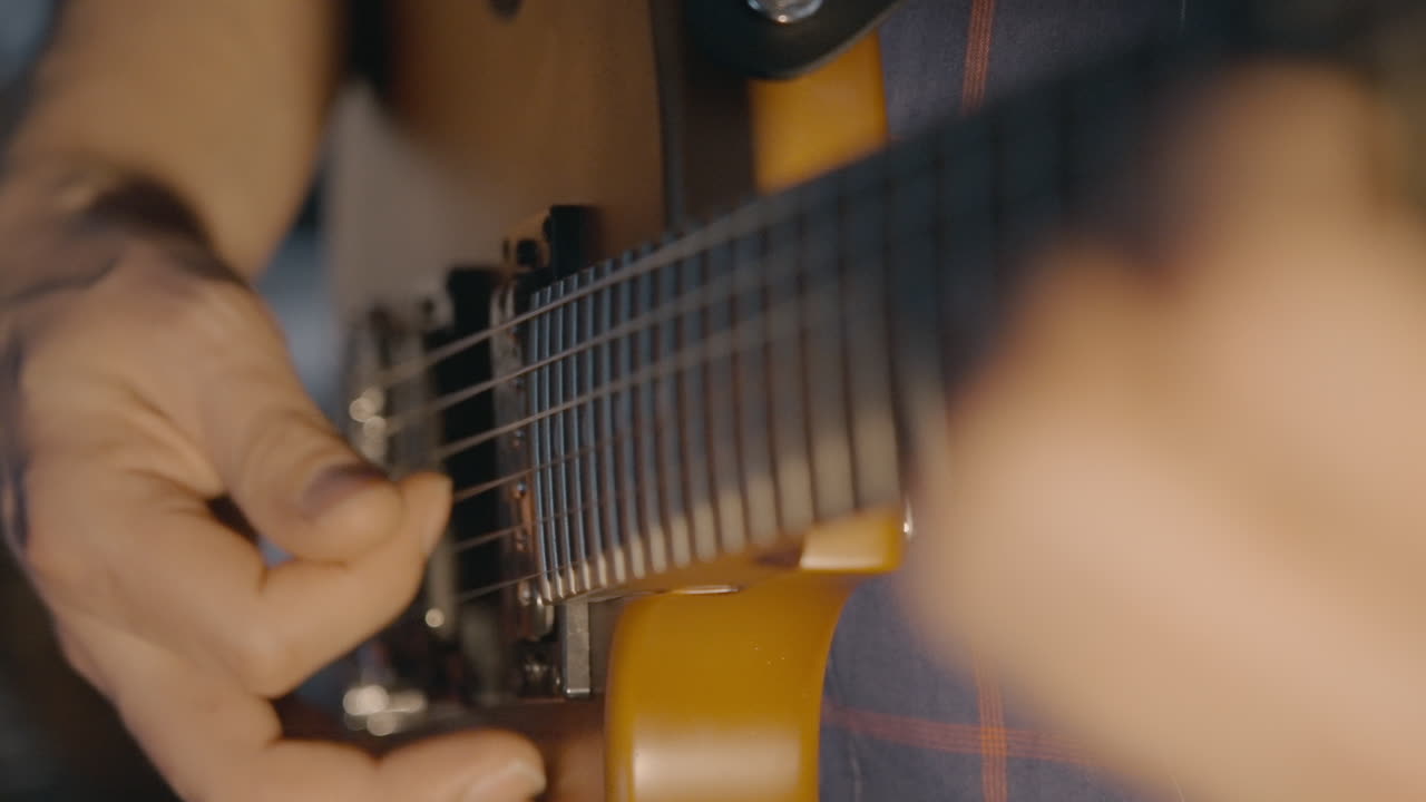 Close-up of Musician's Hands Playing Electric Guitar