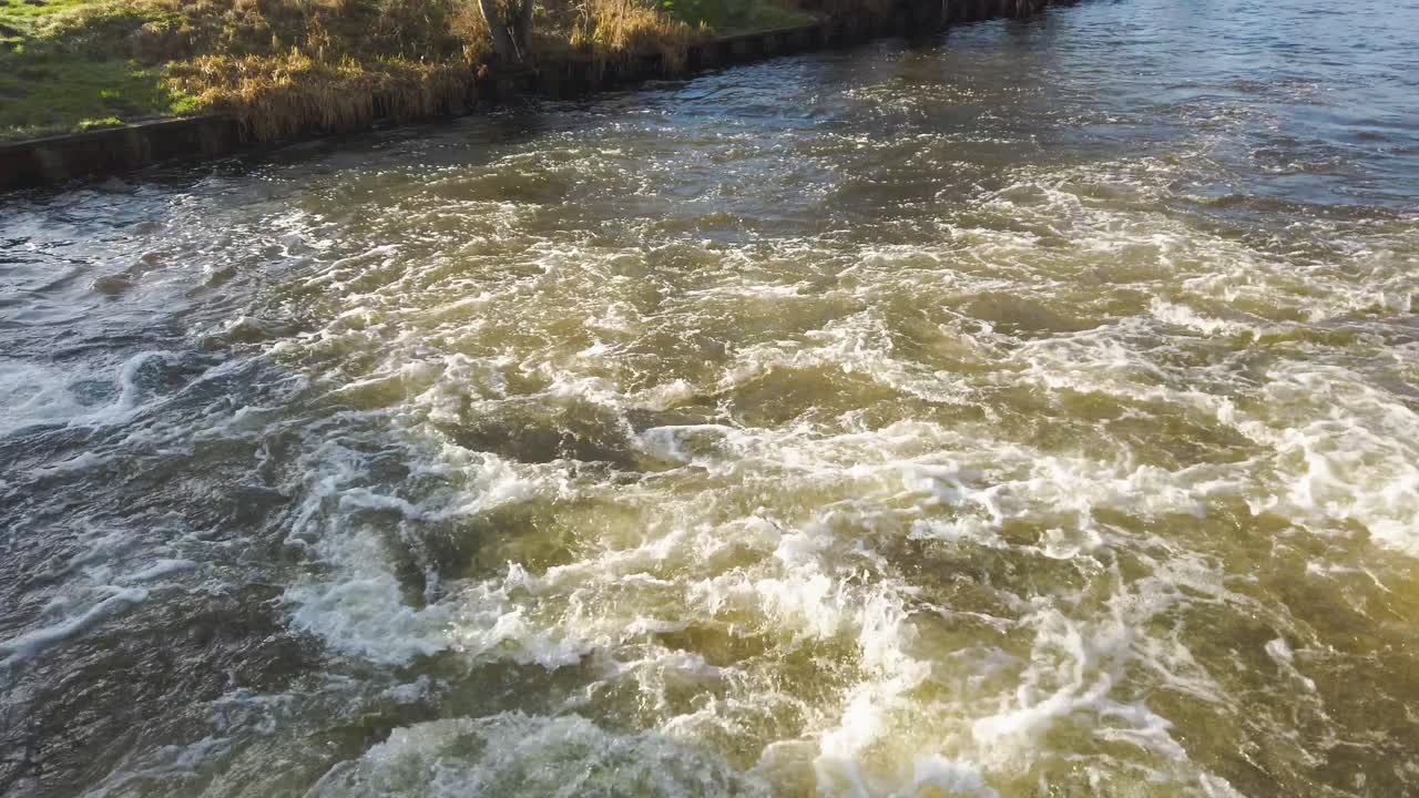 파괴적인 물의 흐름, 영국 노포크의 테트포드 리틀 리버에서 흐르는 물 무거운 침적의 가까이에서 볼 수 있습니다.