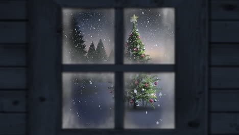 Wooden window frame against snow falling over christmas tree on winter landscape