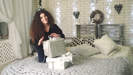woman opening gift boxes. young woman with presents in new year interior in the living room