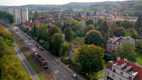 aerial view of modern tram moving on tracks in oliwa, gdansk, poland