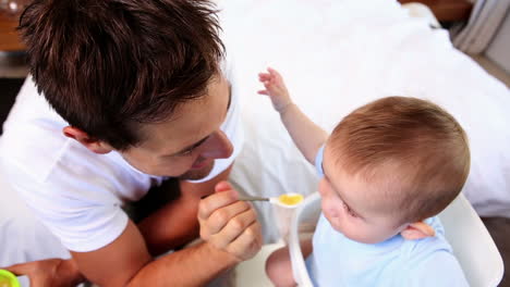 padre feliz alimentando a su hijo pequeño