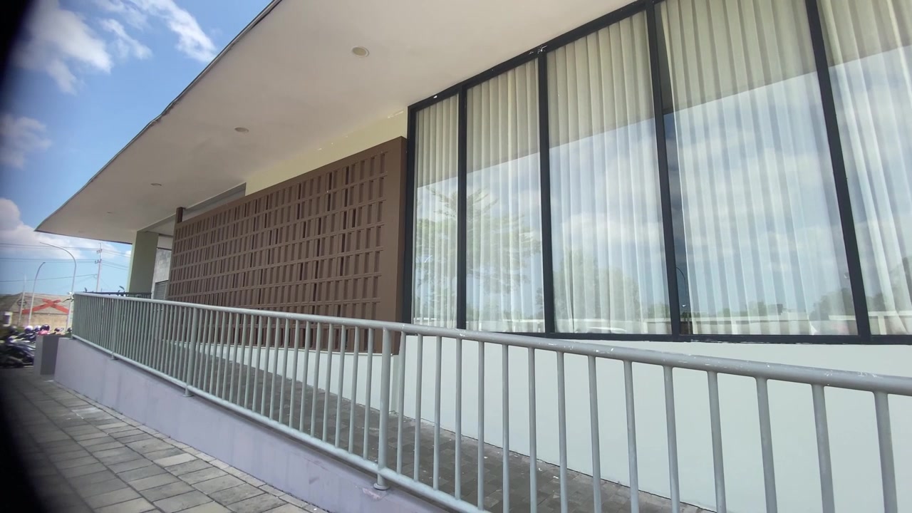 Vista esterna di un edificio moderno con rampa e ampie finestre