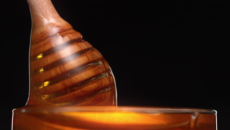 honey pouring from dipper into pot