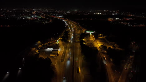 aerial view looking down over traffic vehicles headlights travelling golden illuminated highway interchange at night