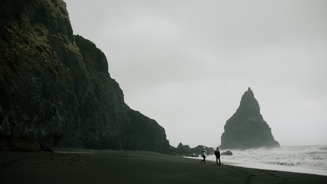 Couple Walking on a Black Sand Beach in Iceland