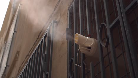 ventilation pipe evaporate steam from inside building in narrow street, close up view