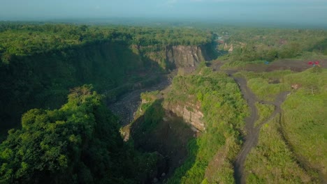 Aerial-view-of-slope-of-volcano-with-Big-valley-with-overgrown-by-trees-on-the-side