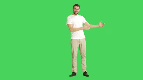 long shot of a casual man doing finger gun/ presenting gesture good for selling your particular product. shot on a green screen background.