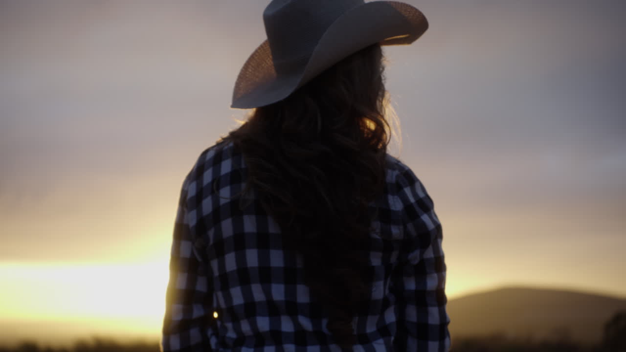 mujer con sombrero de vaquero al atardecer