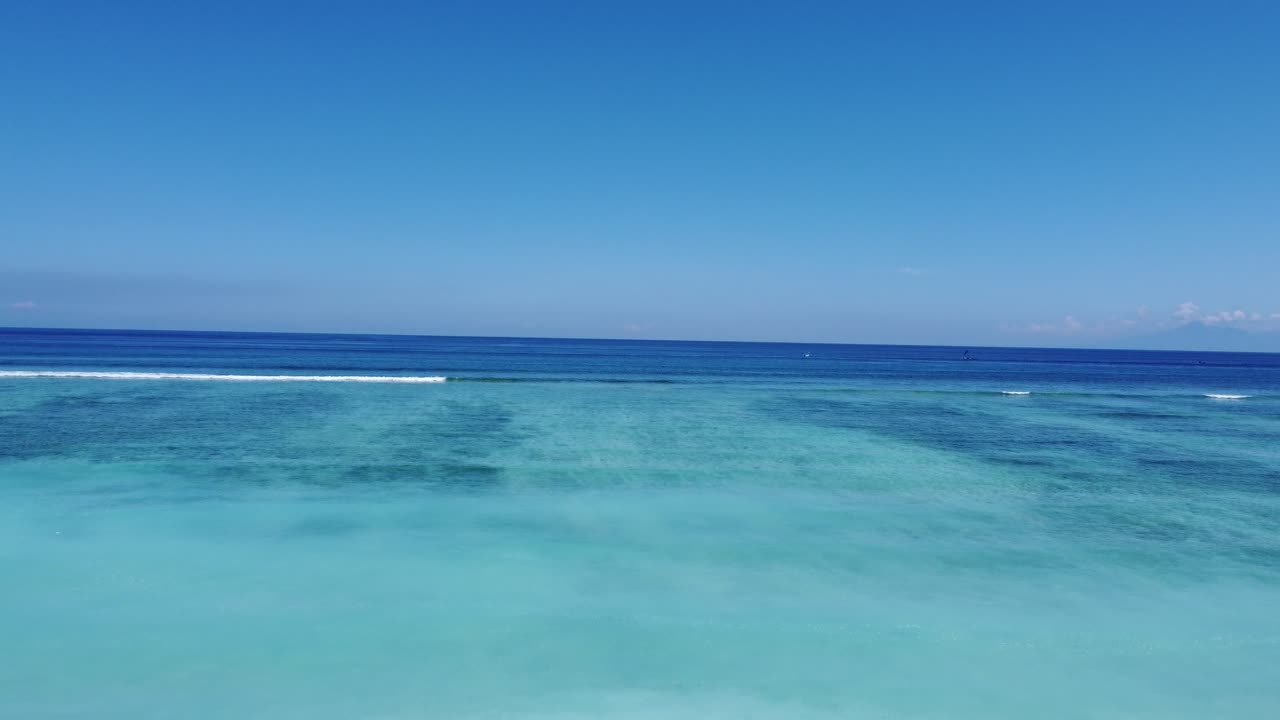Clear Blue Tropical Ocean with Visible Underwater Features and Gentle Waves