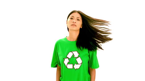 mujer seria con una camisa verde con un símbolo de reciclaje en ella
